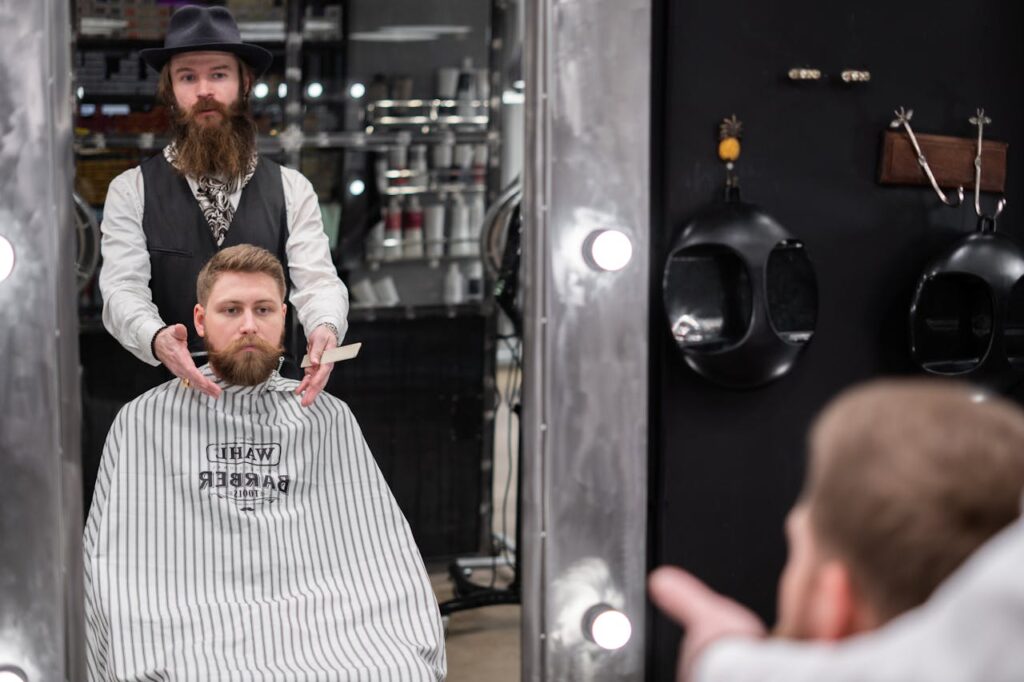 Crafting Captivating Headlines: Your awesome post title goes here A bearded barber grooming a client's beard in a contemporary barbershop.