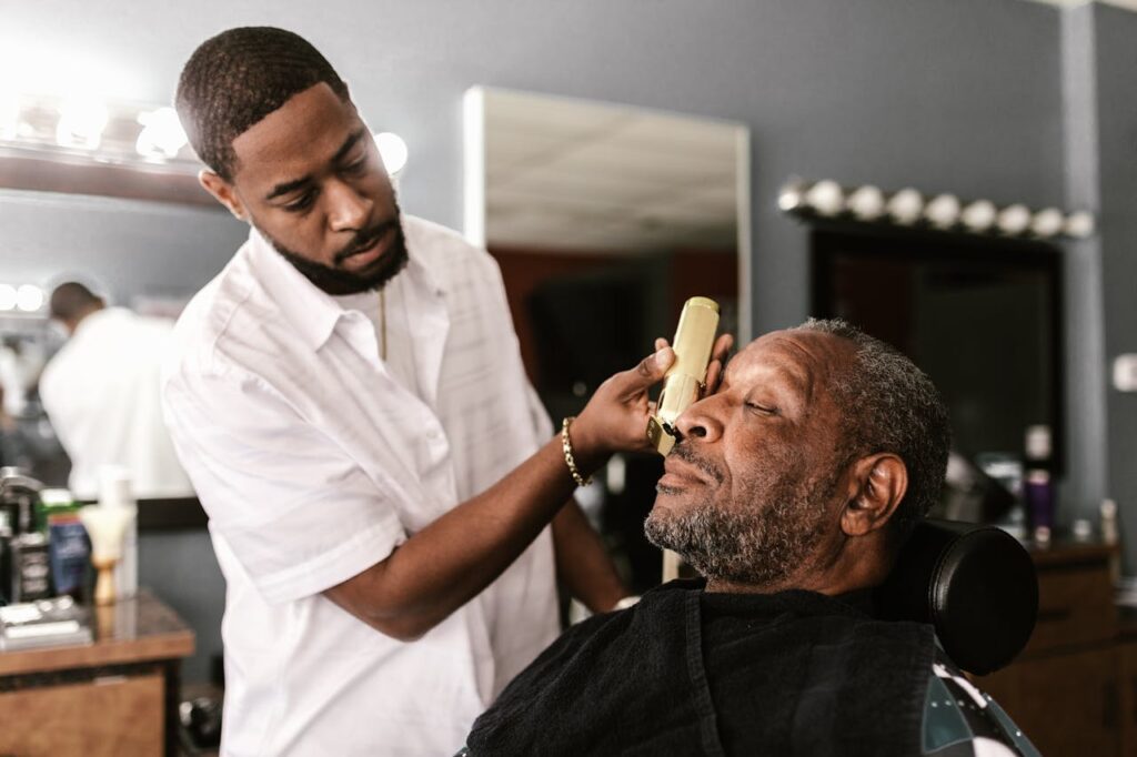 Mastering the First Impression: Your intriguing post title goes here Barber using trimmer on client in a barbershop, capturing a moment of precision and care.